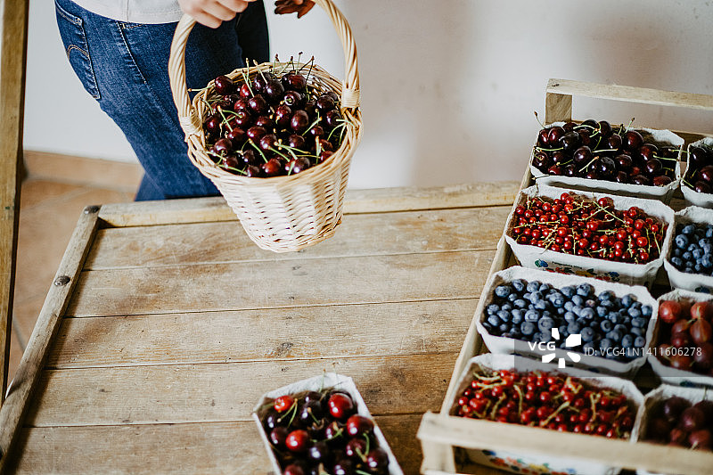 农民在当地农贸店将新鲜草莓放入木箱图片素材