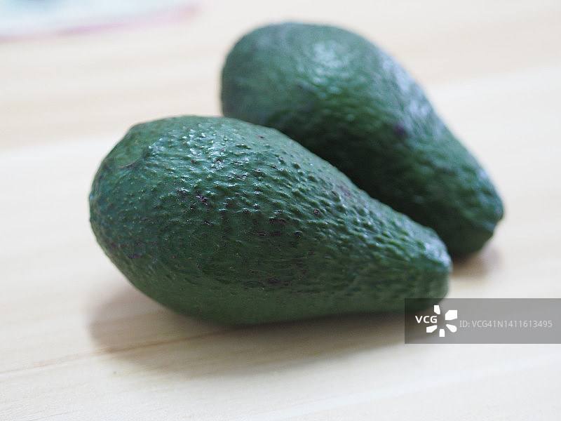 木桌上的绿色牛油果图片素材