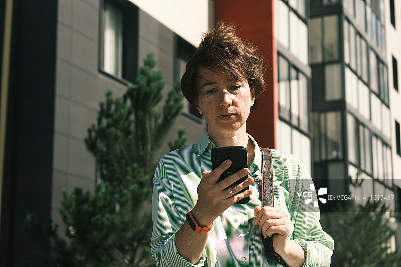 女人在城镇街道上使用手机图片素材