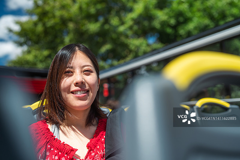 乘坐城市巴士旅游的年轻女游客图片素材