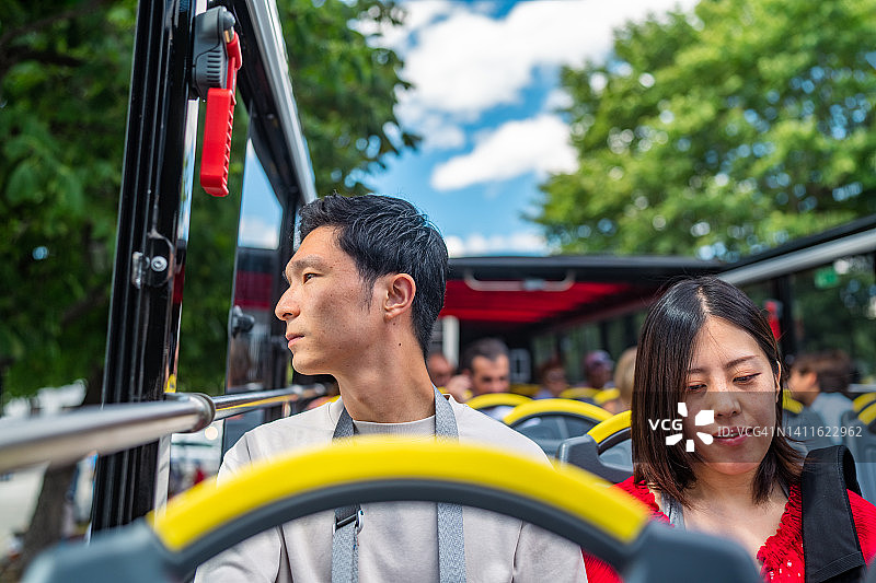 乘坐城市观光巴士并查看地图的年轻游客夫妇图片素材