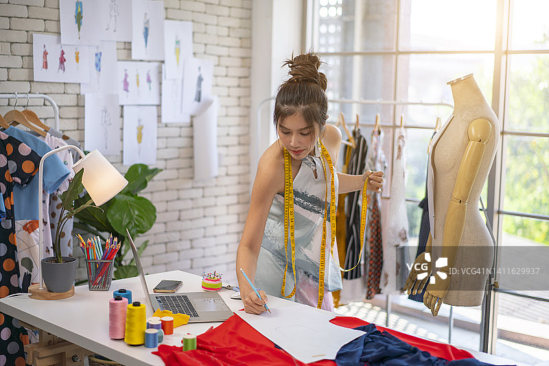 年轻时装设计师在工作室工作图片素材