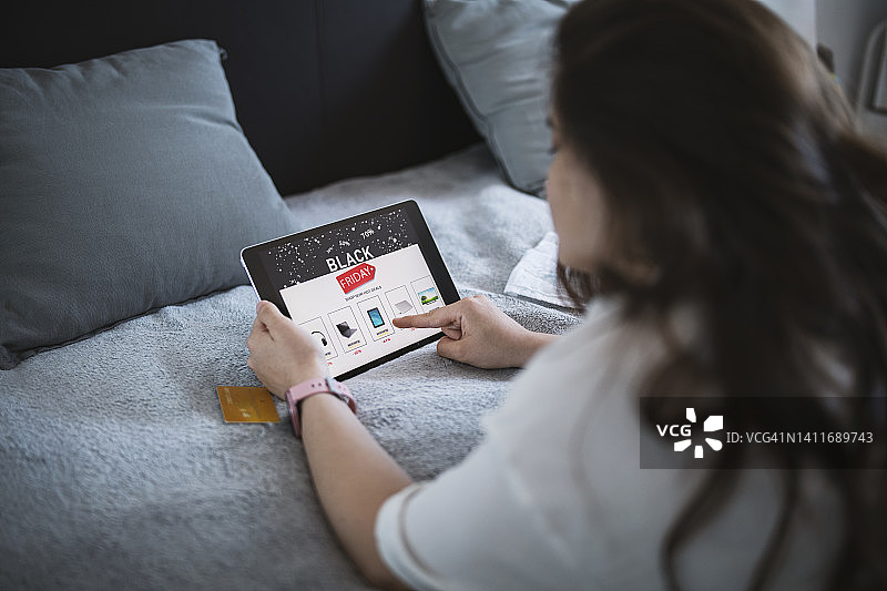 女人在网上购买打折电子产品。黑色星期五促销。图片素材