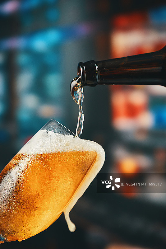 往玻璃杯中倒啤酒图片素材