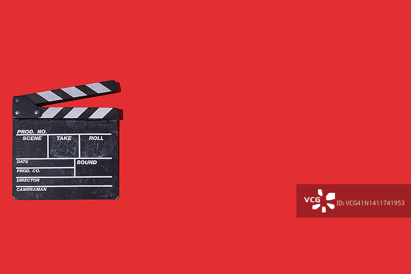 红色背景左侧的旧木制电影场记板，电影行业、电影、娱乐和好莱坞的概念图片素材