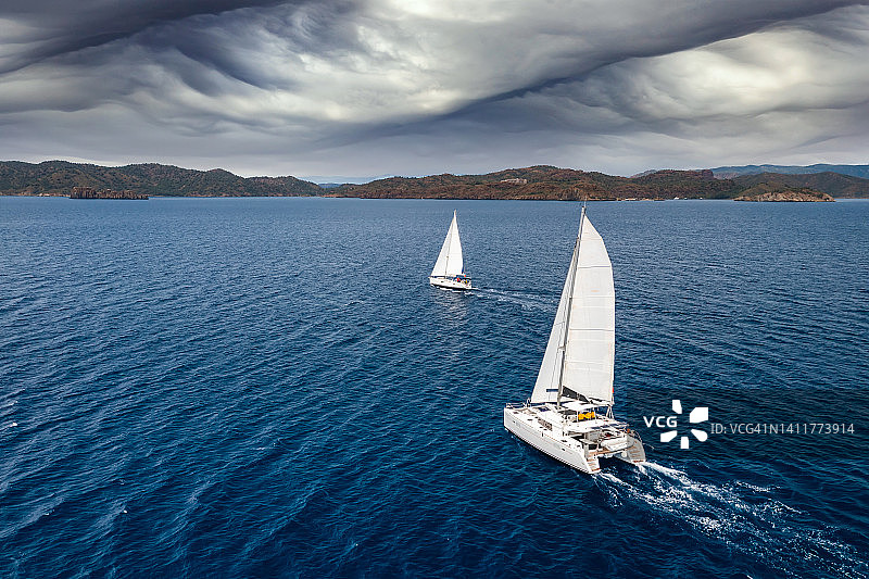 暴风云海背景下的白色风帆游艇图片素材