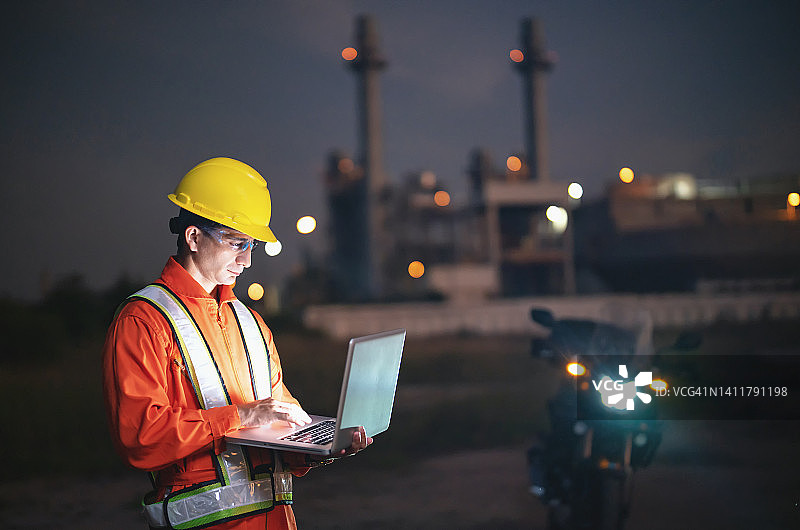 工程师在炼油厂深夜使用平板电脑工作图片素材