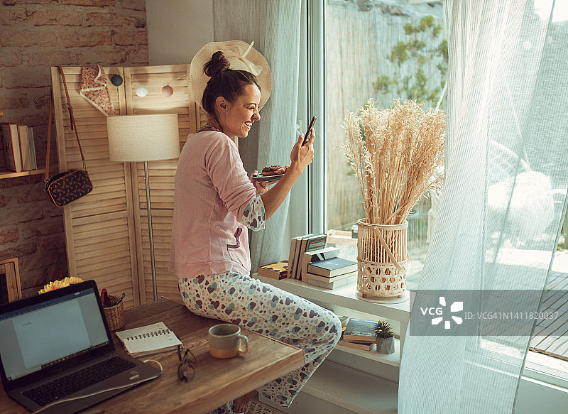 穿着睡衣的女人在醒来后立即使用电脑工作图片素材