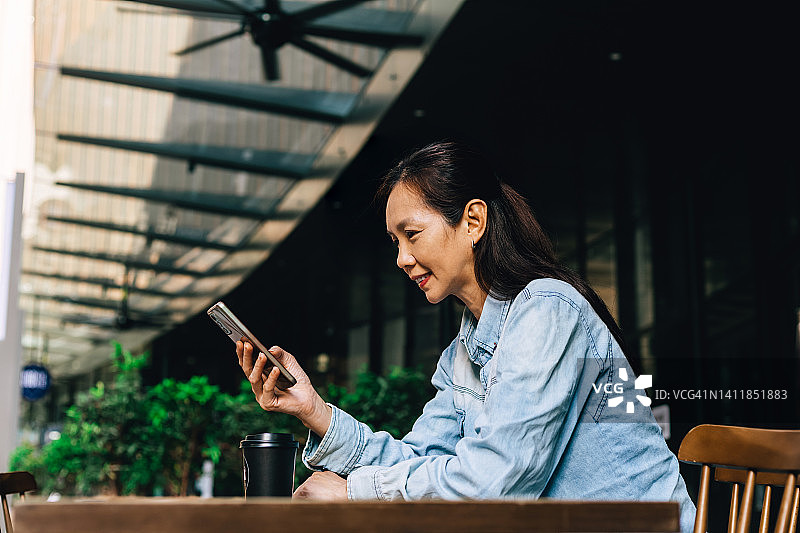 女人在户外咖啡馆查看手机图片素材