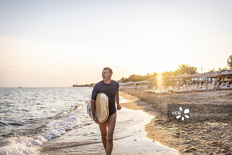 在海滩上行走的冲浪者图片素材