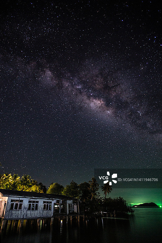 象岛之夜：银河与废弃老屋，地平线上渔船的绿色LED灯图片素材