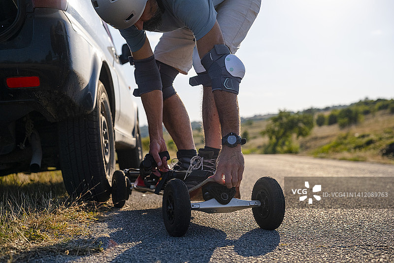 男人在日落时尝试他的电动山地滑板图片素材