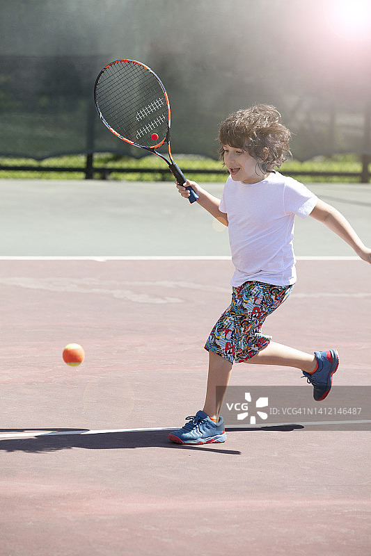 快乐的孩子们在球场上打网球图片素材