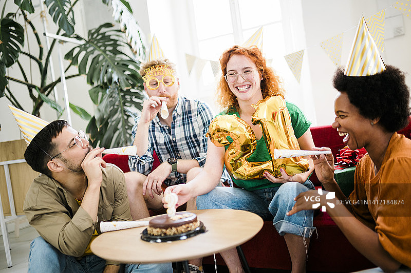 一群年轻人参加生日派对，朋友们玩得很开心图片素材