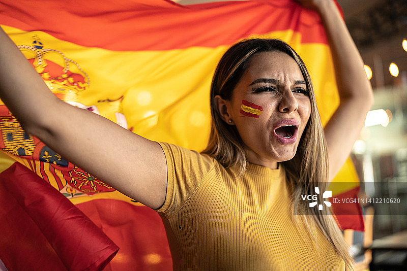 中年女人观看足球比赛挥舞西班牙国旗图片素材