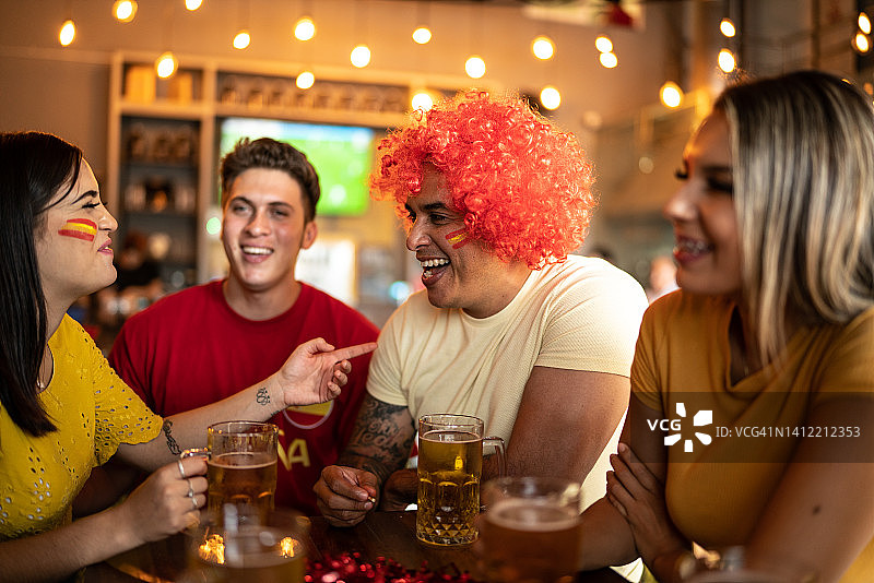 在酒吧里交谈和娱乐的西班牙体育迷图片素材