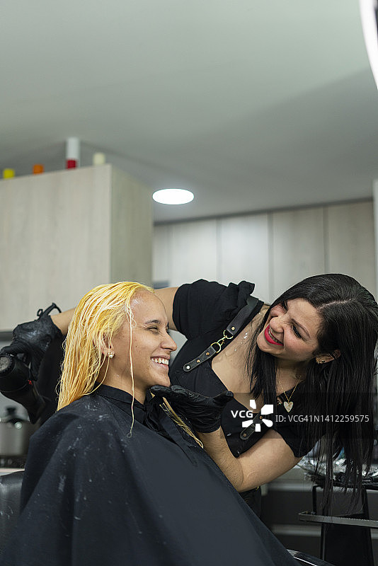 美发沙龙女老板为顾客染发图片素材