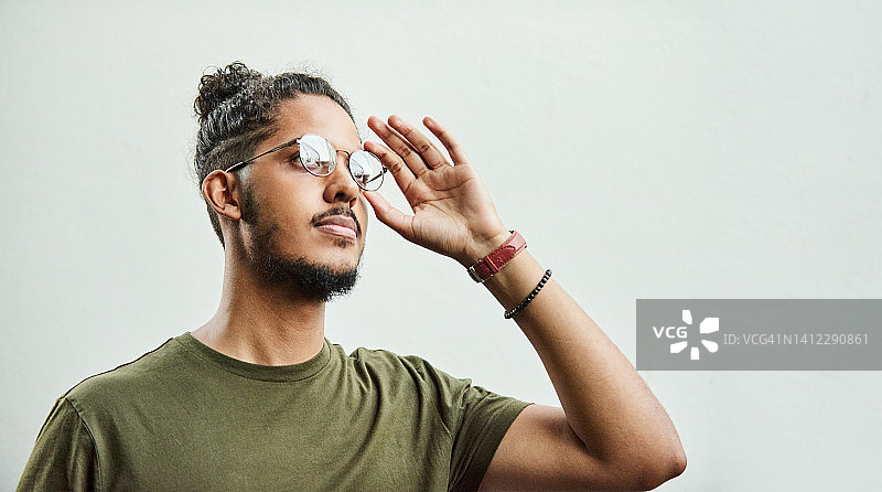 年轻男子在灰色背景下沉思图片素材