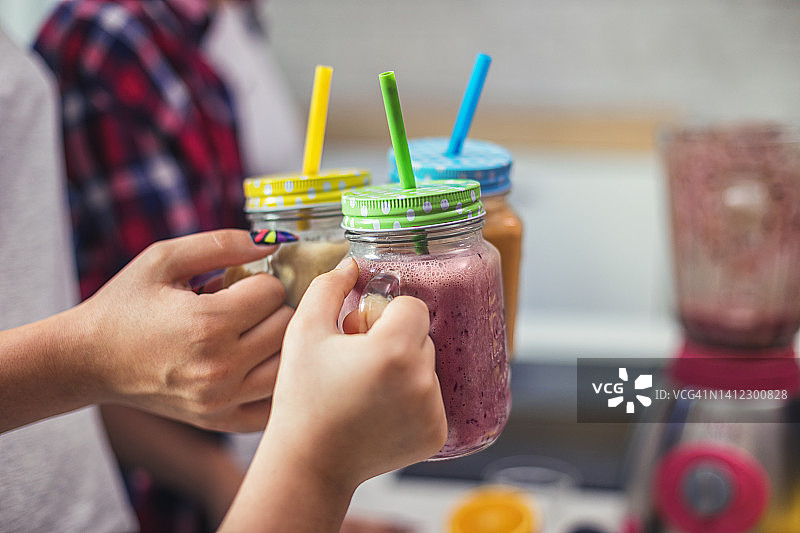 幸福的一家人在厨房用新鲜有机冰沙敬酒图片素材