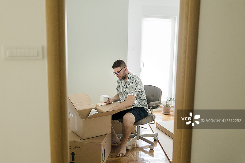 男人拆快递包裹，网上购物图片素材