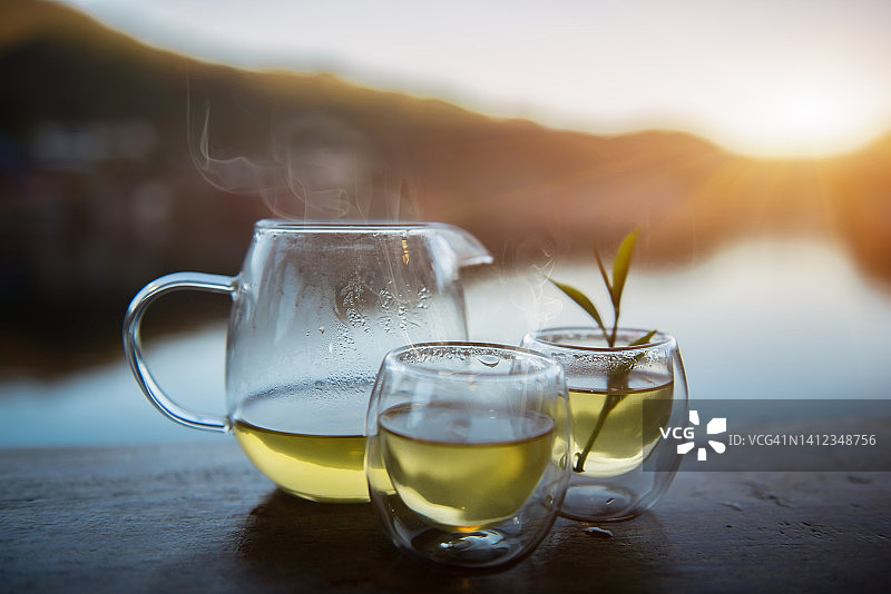 木桌上的绿茶叶茶杯图片素材