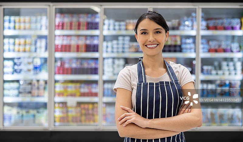 在超市冷藏区工作的快乐女人图片素材