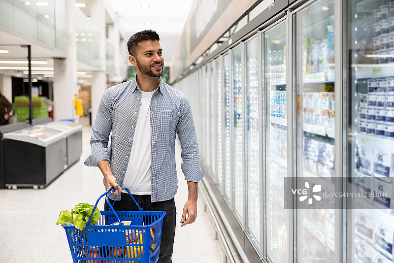 男子在超市冷藏区购物图片素材