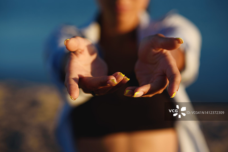 女性手部特写，面部模糊，心情愉悦，正面视角，展现人的力量，健康生活方式，精神健康，个人成就。图片素材