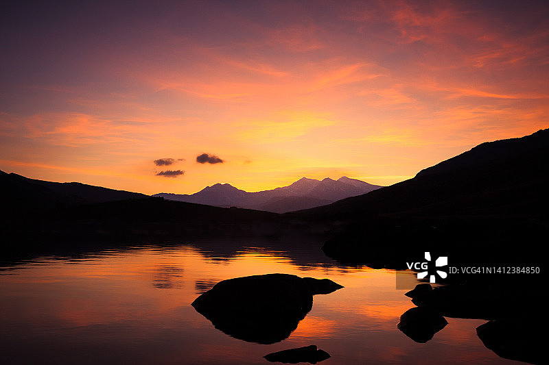 英国威尔士斯诺多尼亚国家公园，夕阳下的斯诺登山脉和林瑙·米姆比尔湖图片素材