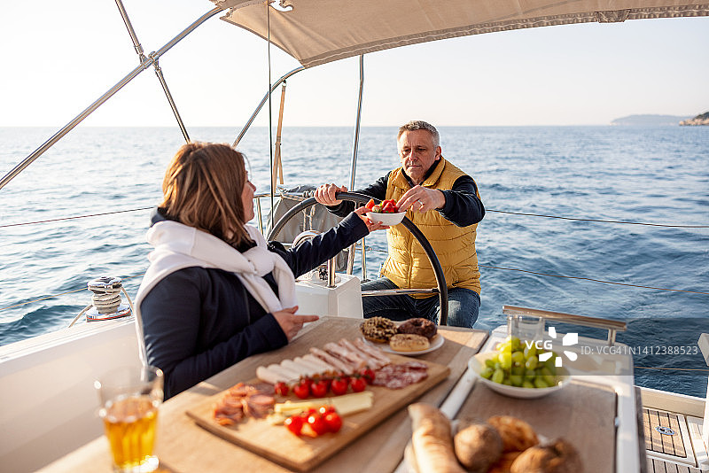 在帆船上享用晚餐的快乐已婚夫妇图片素材
