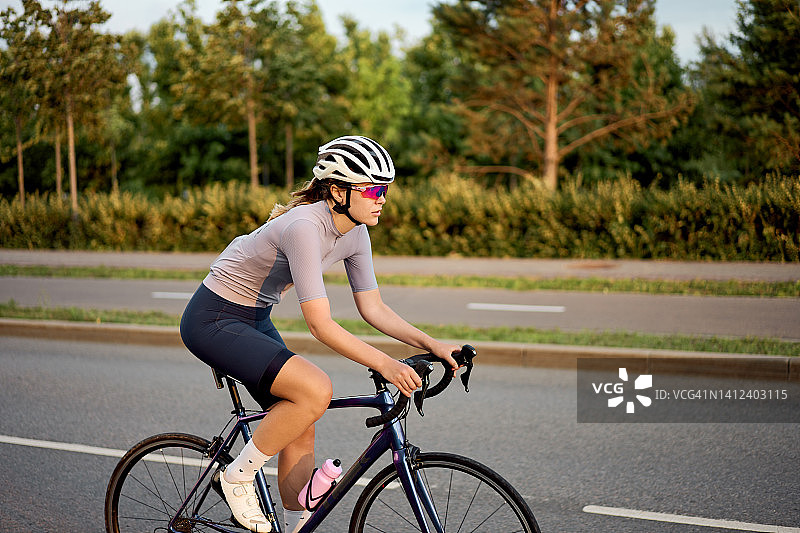 年轻女子在路上骑自行车图片素材