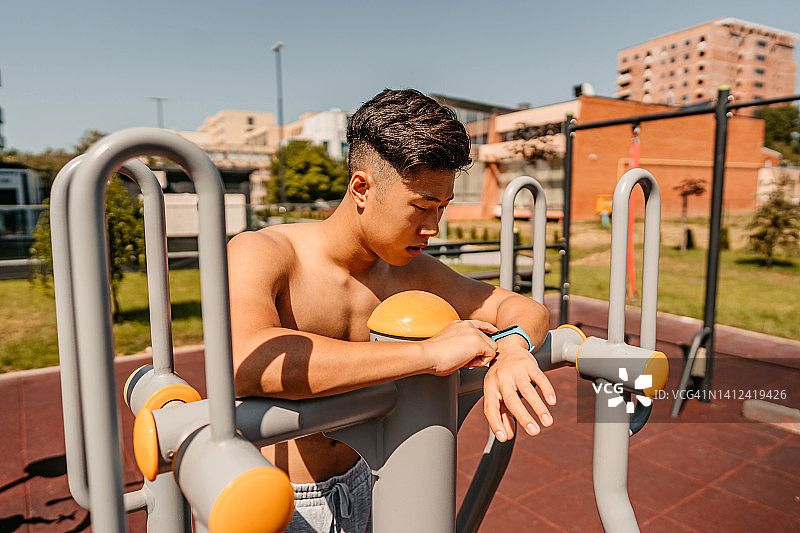 运动员在户外锻炼后查看健身追踪器上的运动数据图片素材