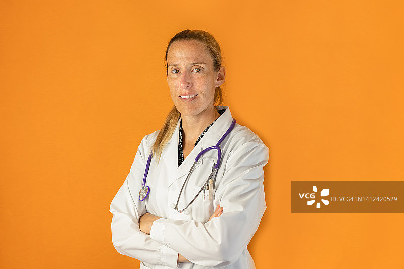 穿着白色医用实验服的女护士肖像，橙色背景图片素材