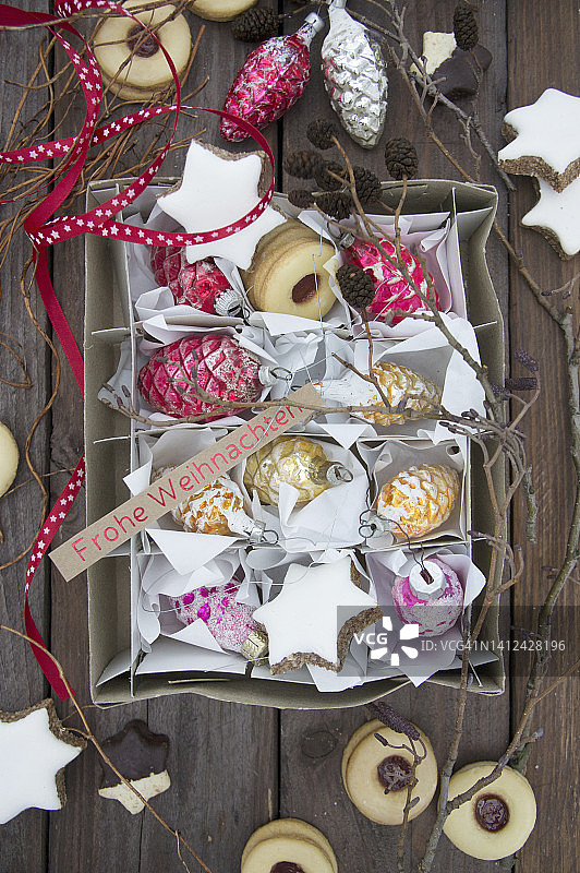 装着复古玻璃松果、树枝、肉桂星和果酱饼干的纸箱图片素材