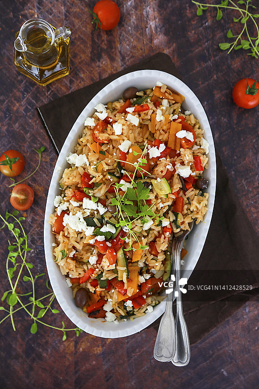 印度香米配辣椒、烤西葫芦、菲达奶酪、樱桃番茄、葱和香草图片素材