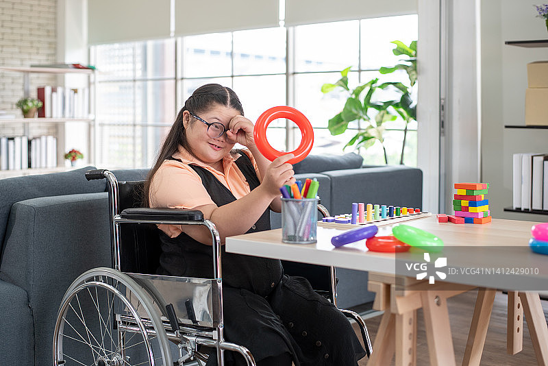 坐在轮椅上在家玩耍的女孩图片素材