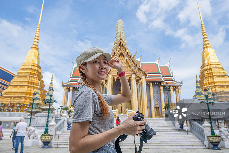 女人在泰国曼谷大皇宫和玉佛寺前拍照图片素材