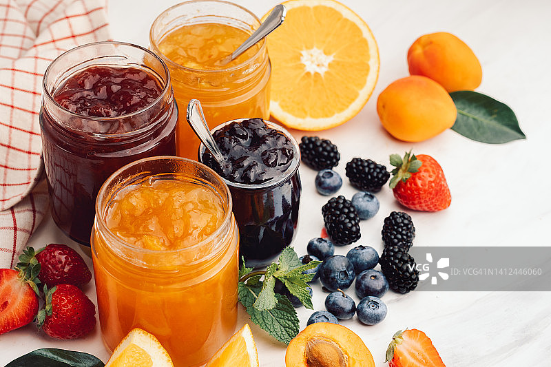 白色桌子上玻璃罐中的自制果酱图片素材