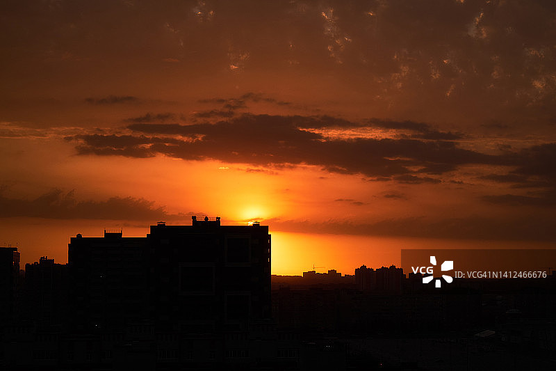 高层多层建筑或在建住宅楼，夕阳天空下的起重机建筑工地，城市黄昏或夜晚的住宅区城市景观图片素材