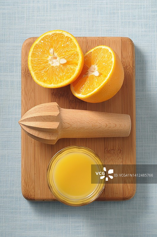 切半橙子、榨汁机与橙汁，俯视图片素材