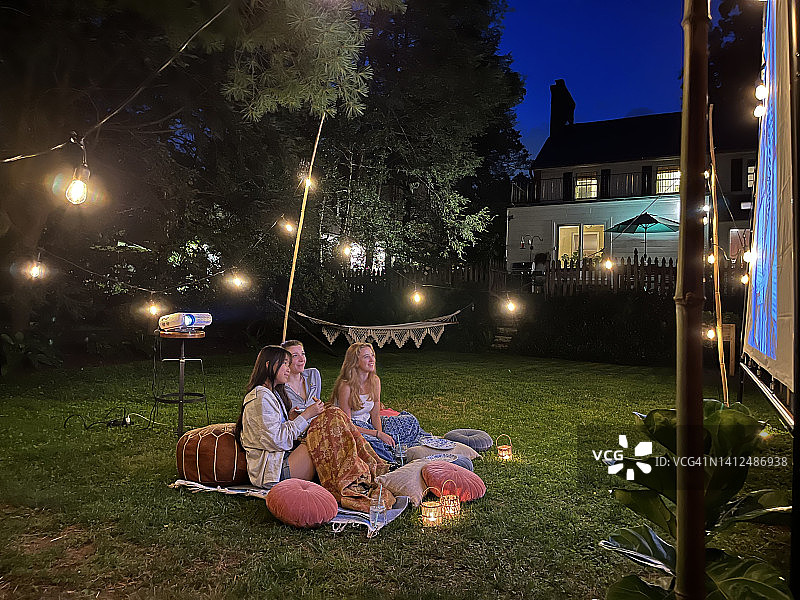 闪烁的灯光和朋友们在户外看电影图片素材