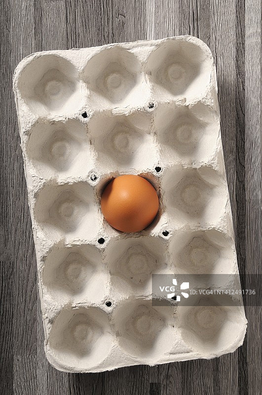 鸡蛋盒里的一个棕色鸡蛋图片素材