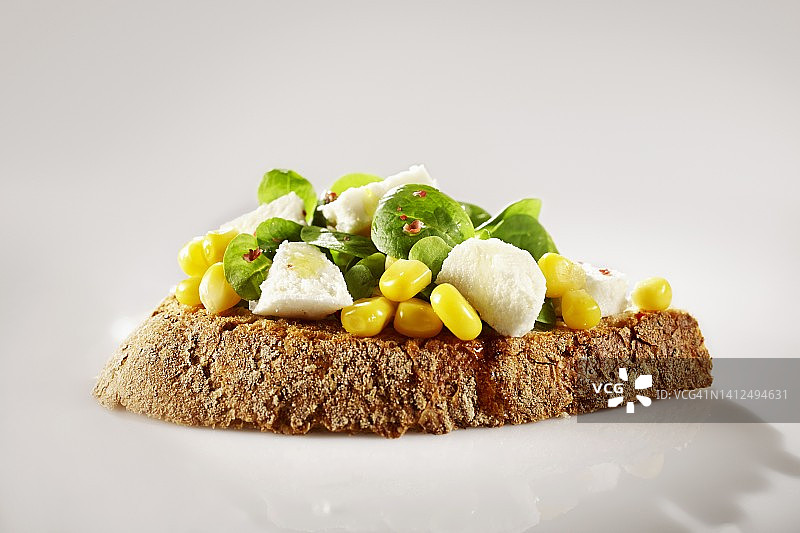 农家面包开放式三明治配羊肉生菜、甜玉米和粉红胡椒图片素材