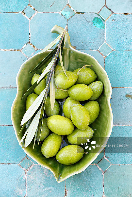 陶瓷碗里的带枝绿色橄榄图片素材