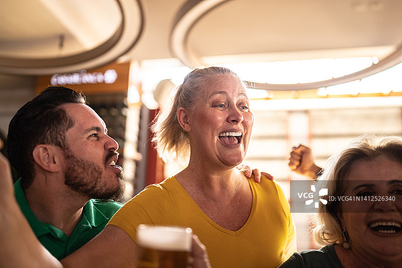 体育迷在酒吧庆祝并喝啤酒图片素材