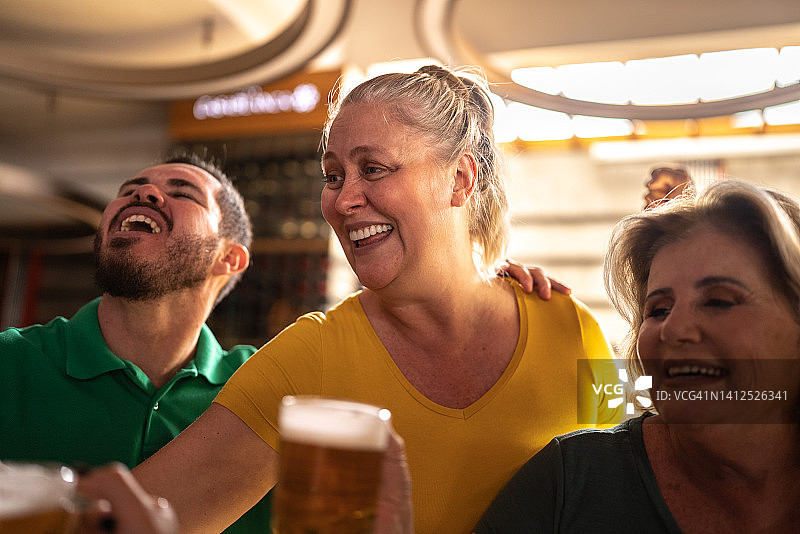 体育迷在酒吧庆祝并喝啤酒图片素材