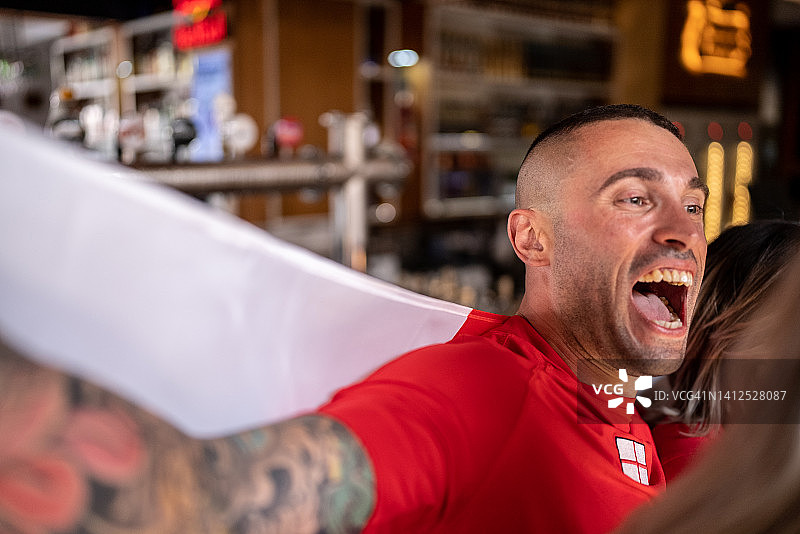 中年男人在酒吧庆祝英格兰队获胜图片素材