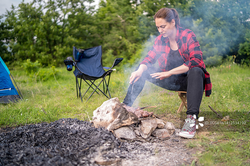 在荒野中篝火烹饪的女人图片素材