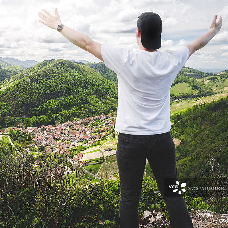 徒步旅行者在阿尔卑斯山顶的法国葡萄酒村庄欣赏葡萄园的景色图片素材