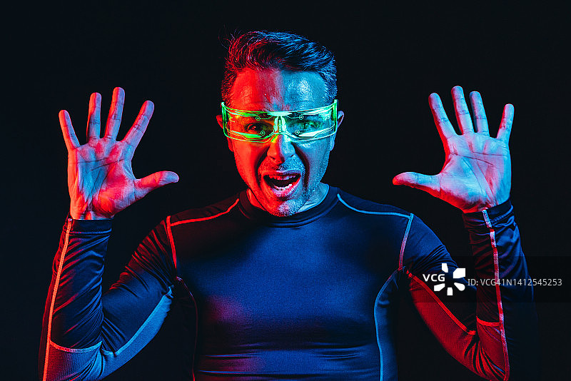 佩戴绿色灯光电子眼镜、身穿蓝色紧身T恤的男子图片素材